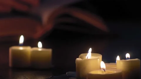 White Man's hands flip pages of a book while lit by candles 4K Stock Footage 194443750