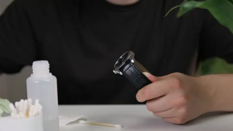 White mans hands wipe a watch with a leather strap with a special cloth. The man Stock Footage 313651468