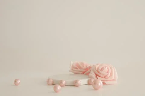 White marble podium on the white background with pink pearls and flowers. Pod Stock Photos