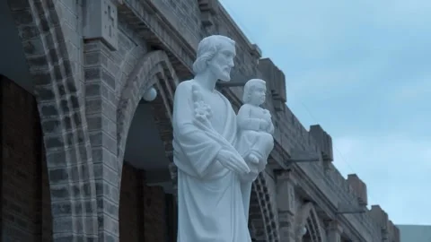 A white marble statue of Saint Joseph holding the infant Jesus Stock Footage 340628439