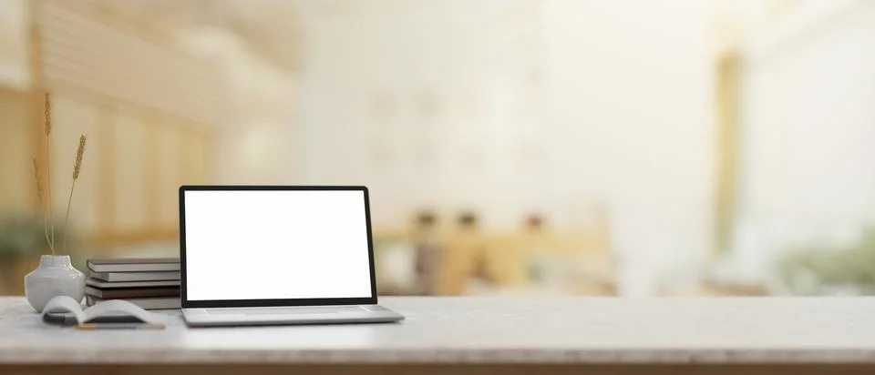 A white marble table features a laptop mockup with a blurred background of .. イラスト素材