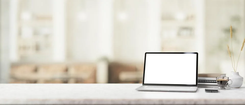 A white marble table features a white-screen laptop mockup in a contemporar.. イラスト素材