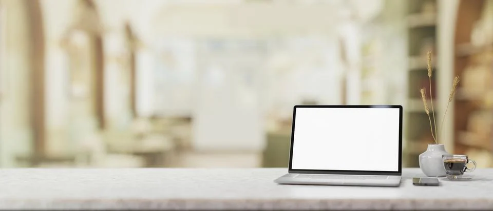 A white marble table features a white-screen laptop mockup in a contemporar.. イラスト素材
