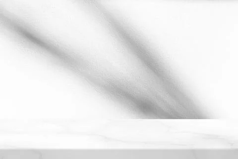 White Marble Table with Sunlight Shadows on Wall Background Foto stock
