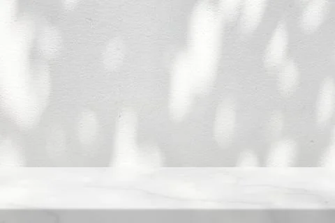 White Marble Table with Tree Shadow and Bokeh on Concrete Wall Texture Backgr Stock Photos