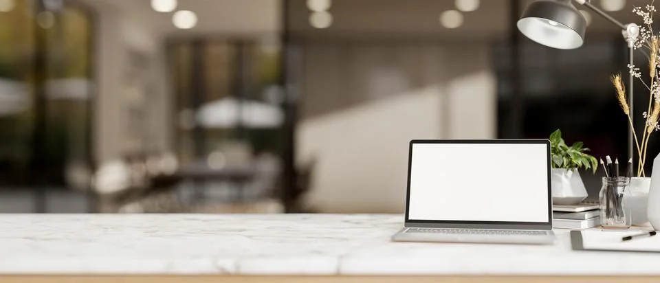 A white marble tabletop features a white-screen laptop computer in a modern.. 스톡 일러스트