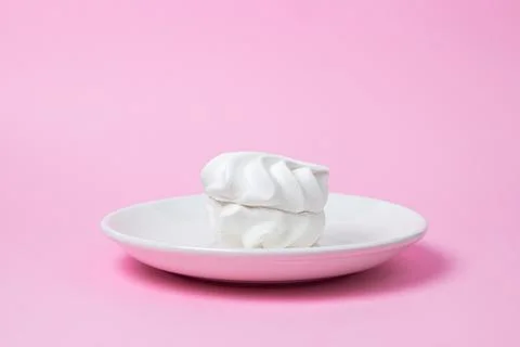 White marshmallow on a pink background. White marshmallow on a white plate. Stock Photos