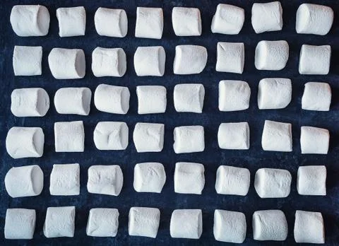 White marshmallows on a black background. pattern of white marshmallows. Stock Photos