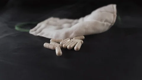 White mask and pills fall on a black background Stock Footage 127180650