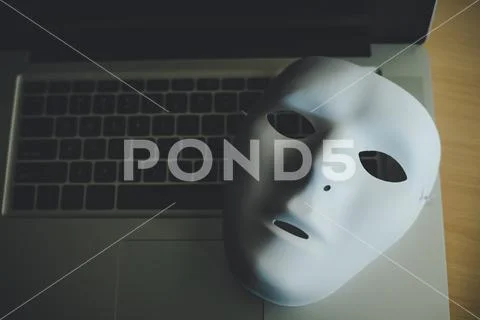 White mask placed on the laptop - concept fraud of social online Stock Photos