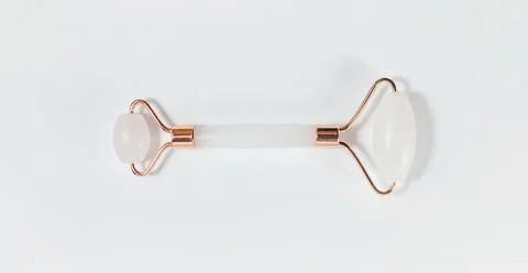 White massage quartz roller for the face close-up isolated on a white background Stock Photos