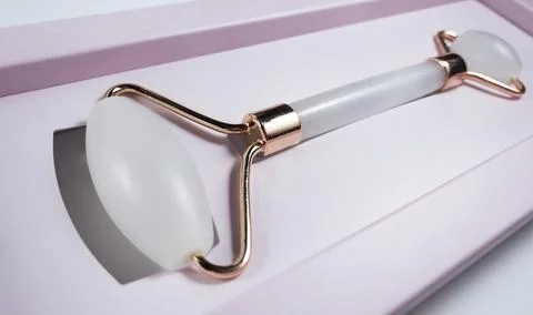 White massage quartz roller for the face close-up in pink gift box Stock Photos