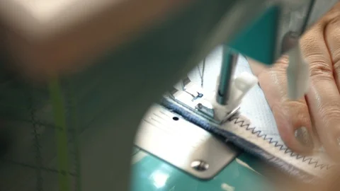 White material is fed through a sewing machine 動画素材 129517685
