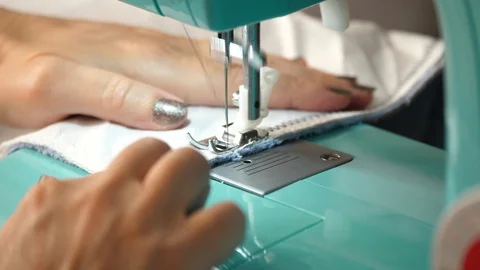 White material is fed through a sewing machine 動画素材 129517786