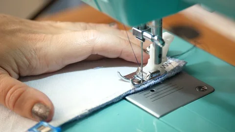 White material is fed through a sewing machine 動画素材 129517823