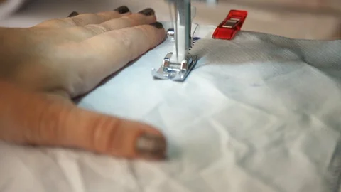 White material is fed through a sewing machine 動画素材 129518225