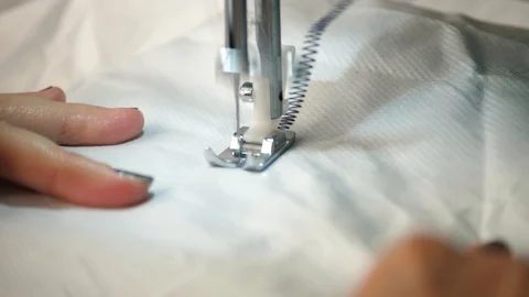 White material is fed through a sewing machine Stock Footage 129518240