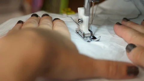 White material is fed through a sewing machine 動画素材 129518598