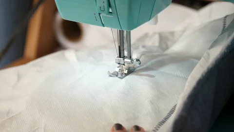 White material is fed through a sewing machine 動画素材 129518825