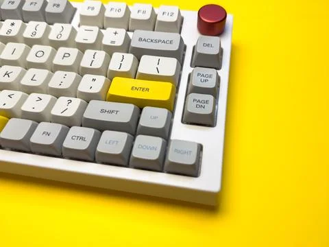 White mechanical keyboard with bright Enter key on bright yellow background, Stock Photos