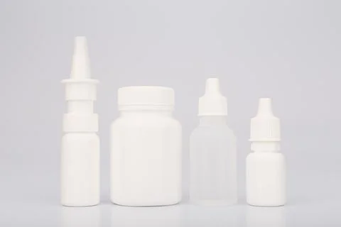 White medication bottles in a row isolated on white background Stock Photos