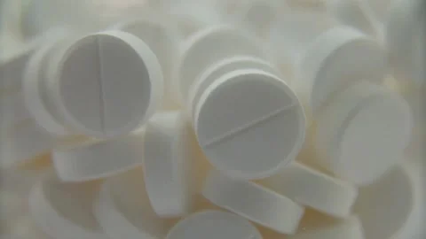 White medicine tablets moving inside a container during production Stock Footage 333875265