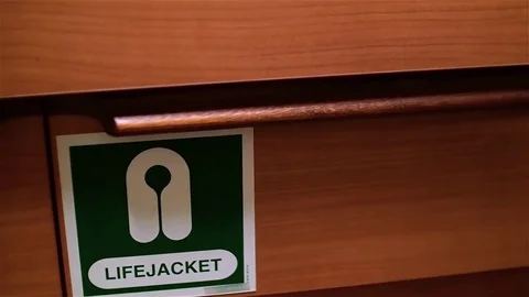 White men's hand opens locker and takes orange life jacket Stock Footage 72139328