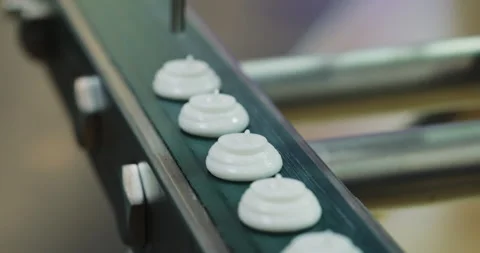 White meringue sweets move along a conveyor during automated confectionery Stock Footage 346226817