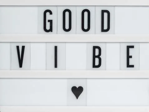 White message board with the message Good Vibe with a heart below it. Stock Photos