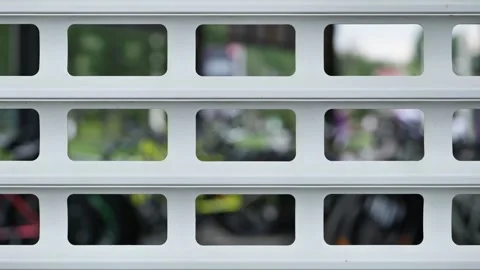 White metal roller shutter with geometric pattern and blurred background with Stock Footage 330346134