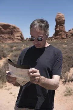 White middle aged man looking at map while lost in the desert of southern UT Stock-Fotos