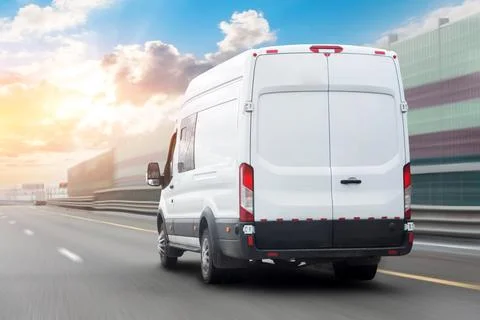 White mini bus is moving motion blur along city highway bypass road with beau Stock Photos
