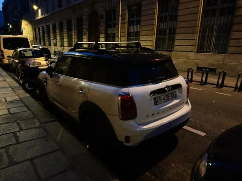 White Mini Cooper parked on a quiet Paris, France street at night with hist.. Stock Photos