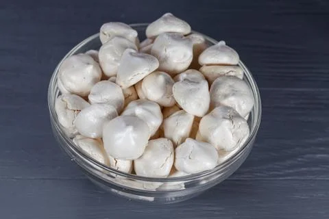 White mini meringue in transparent vase on a wooden background Stock Photos