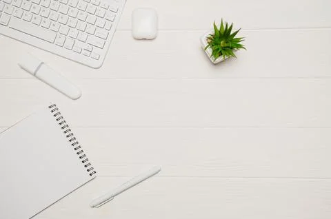 White minimal office workspace flat lay with modern wireless keyboard, earb.. Stock Photos