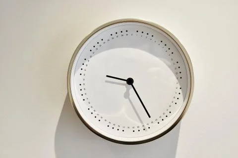 White minimalist clock without numbers hanging on the wall Stock Photos