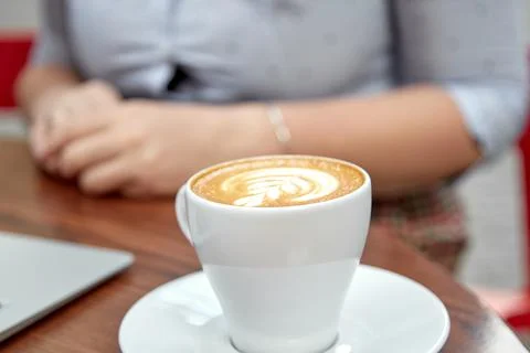 White mock up of cup of coffee on the table outside in foreground of women Stock Photos