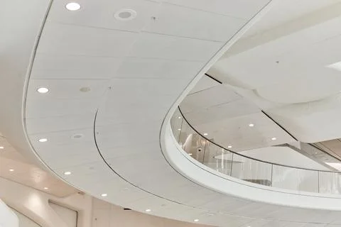 White modern ceiling bridge inside clean subway with spotlights and glass rails Foto stock