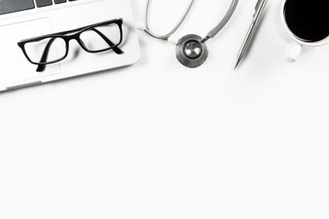 White modern doctor's desk table with stethoscope, coffee cup and office supp Stock Photos