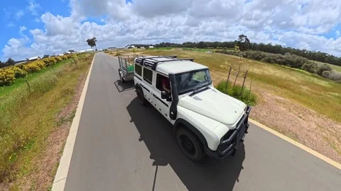 White Modern Four Wheel Drive Vehicle Towing Utility Trailer Along Rural Road Stock Footage 331609378