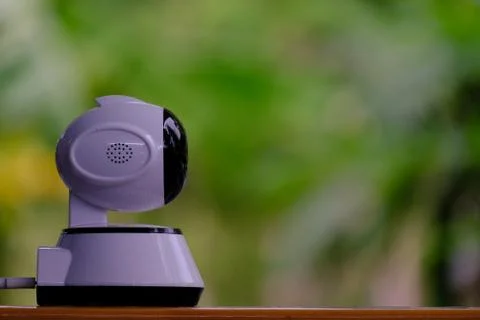 A white modern indoor CCTV camera with internal infrared is rotating to check Stock Photos