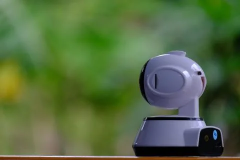 A white modern indoor CCTV camera with internal infrared is rotating to check Stock Photos