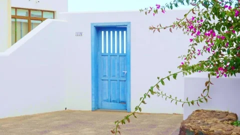 White modern white wall entrance greek looking house with blue rustic door Stock Footage 281860168