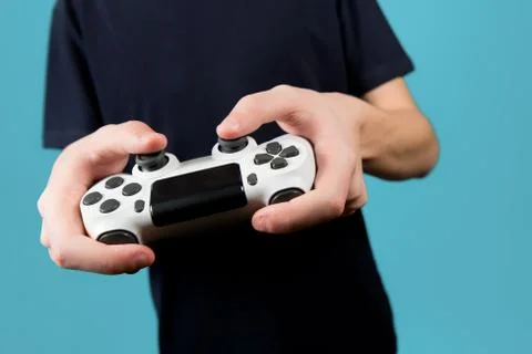 White modified joystick from a game console in the hands of a teenager. Stock Photos