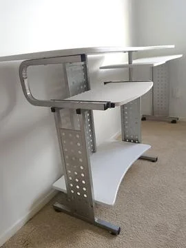White modular computer desk with multiple shelves, metal supports, Stock Photos