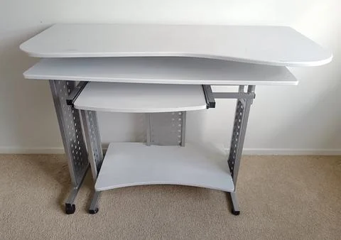 White modular computer desk with multiple shelves, metal supports, Stock Photos