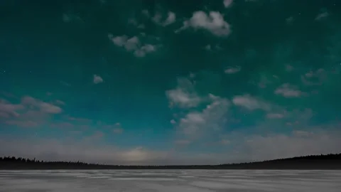 White moon lit clouds drift across a panoramic scene with a weak green Aurora  Stock Footage 153034428