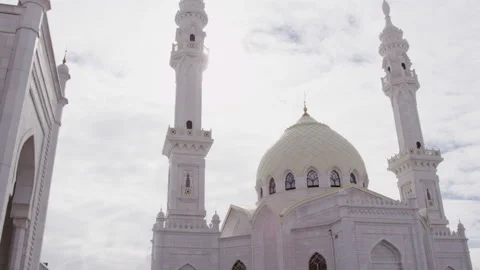 White Mosque illuminated by sunlight breaking through clouds Stock Footage 228781138