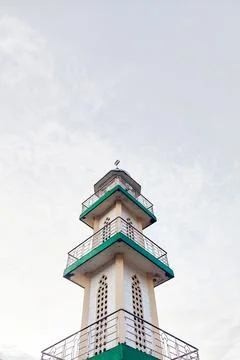 White mosque tower with clouds in the background Stock Photos