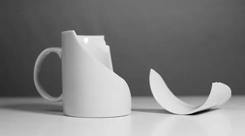White mug breaks and splinter falls beside her Stock Footage 40431226